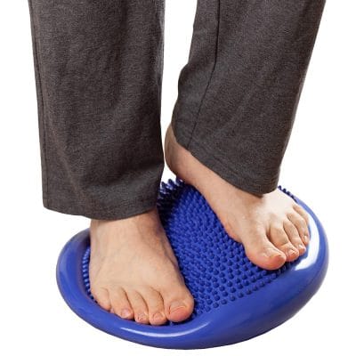Person standing barefoot on Relaxus ExerSit Cushion blue balancing core stability
