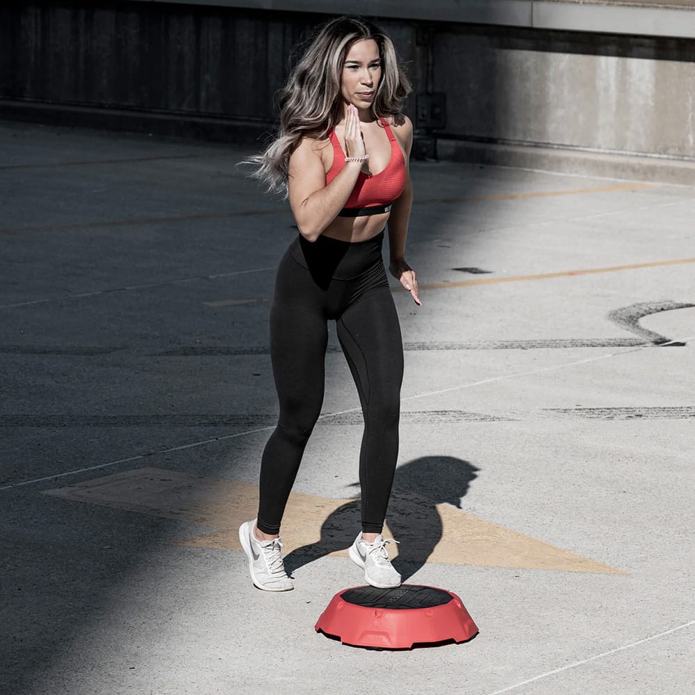 Woman performing step-up exercise on a CoreFX aerobic step riser