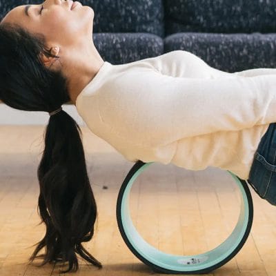 Person using 12-inch Chirp Wheel+ for full back mobility and gentle stretching
