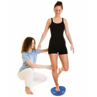 Person performing balance training on a Concorde Wobble Disk to improve core stability