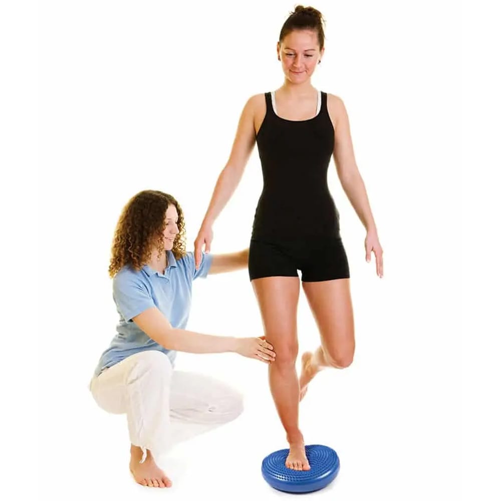 Person performing balance training on a Concorde Wobble Disk to improve core stability