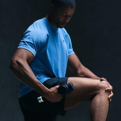Person using the Hypervolt 2 Pro massage gun on the thigh for deep tissue recovery and post-workout relief.