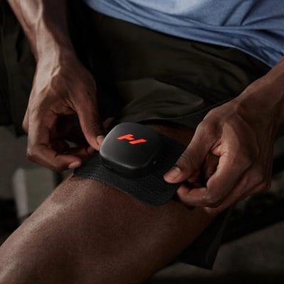 Person using the Hyperice Venom Go pad on the front of the thigh for targeted muscle relief