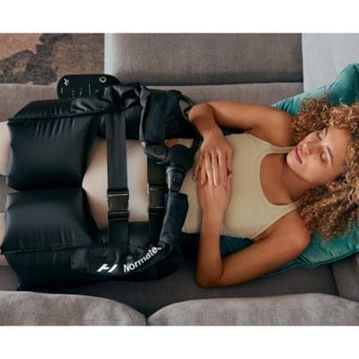 Athlete wearing Normatec Hip Attachment connected to a Normatec system for hip and lower back recovery