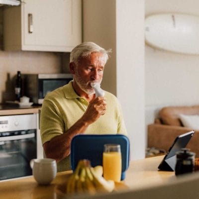 Person using POWERbreathe Smart Adaptor while viewing ActiBreathe app on iPad