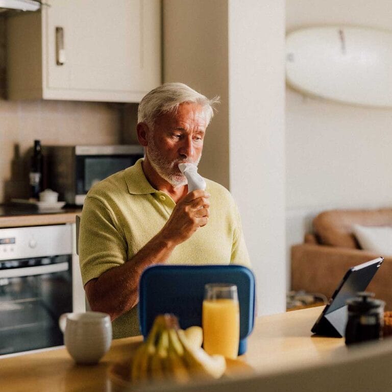 Person using POWERbreathe Smart Adaptor while viewing ActiBreathe app on iPad