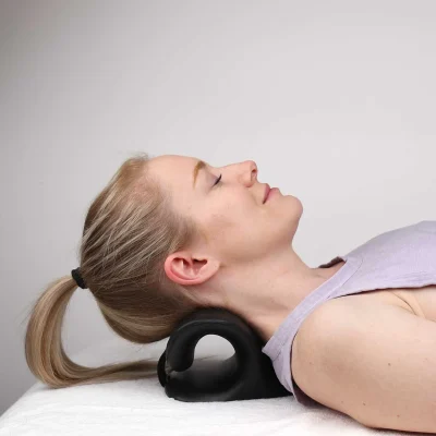 Person resting with heated cervical neck support at home