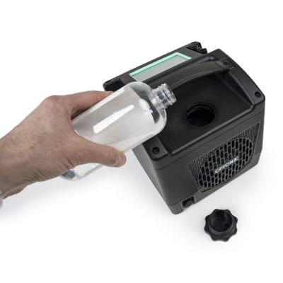 Cryon-X One cold compression therapy unit being filled with cooling fluid using a bottle