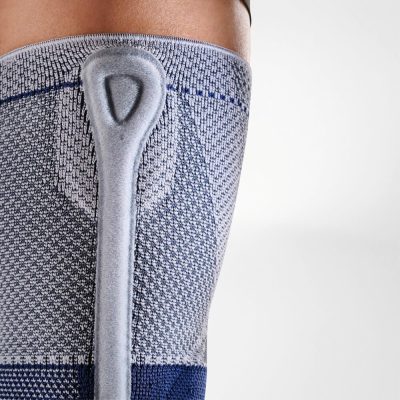 Side view of the titan and blue Bauerfeind GenuTrain P3 knee brace showing the side band and finger area for easier pull-on application